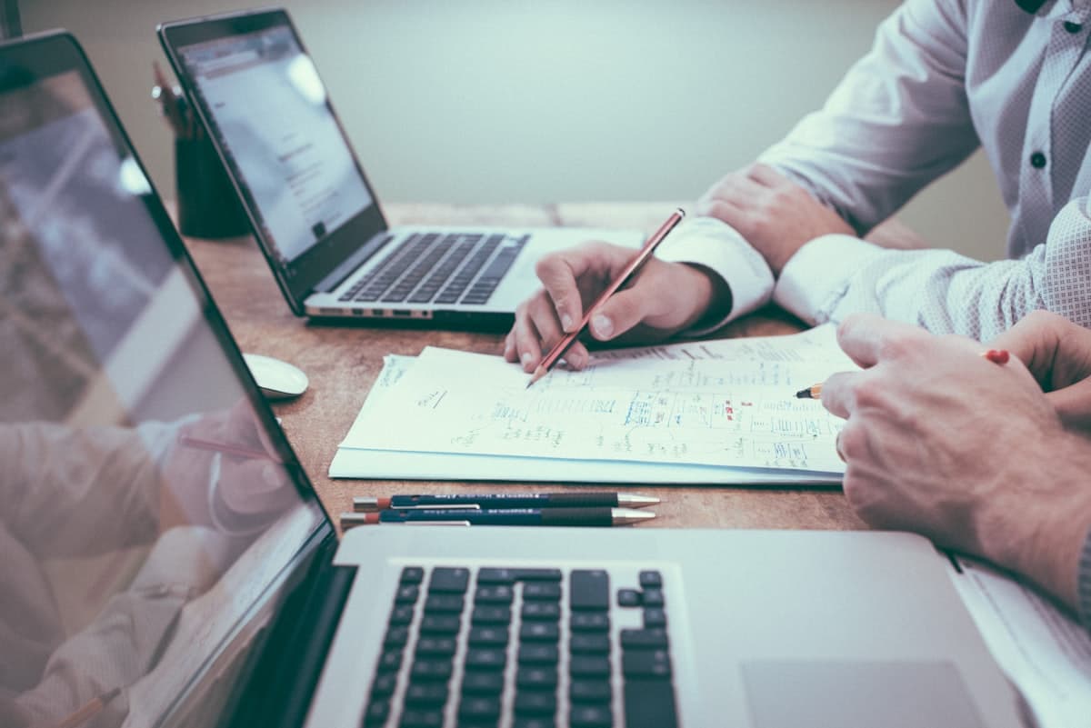 Profissionais revisando um plano patrimonial sobre documentos e gráficos